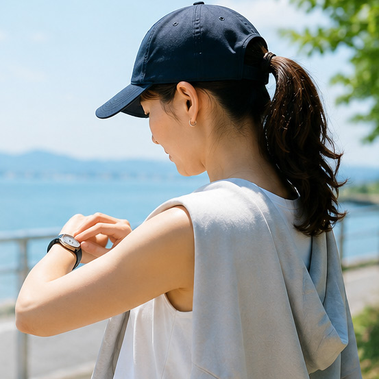 真夏の屋外で腕時計を確認する女性
